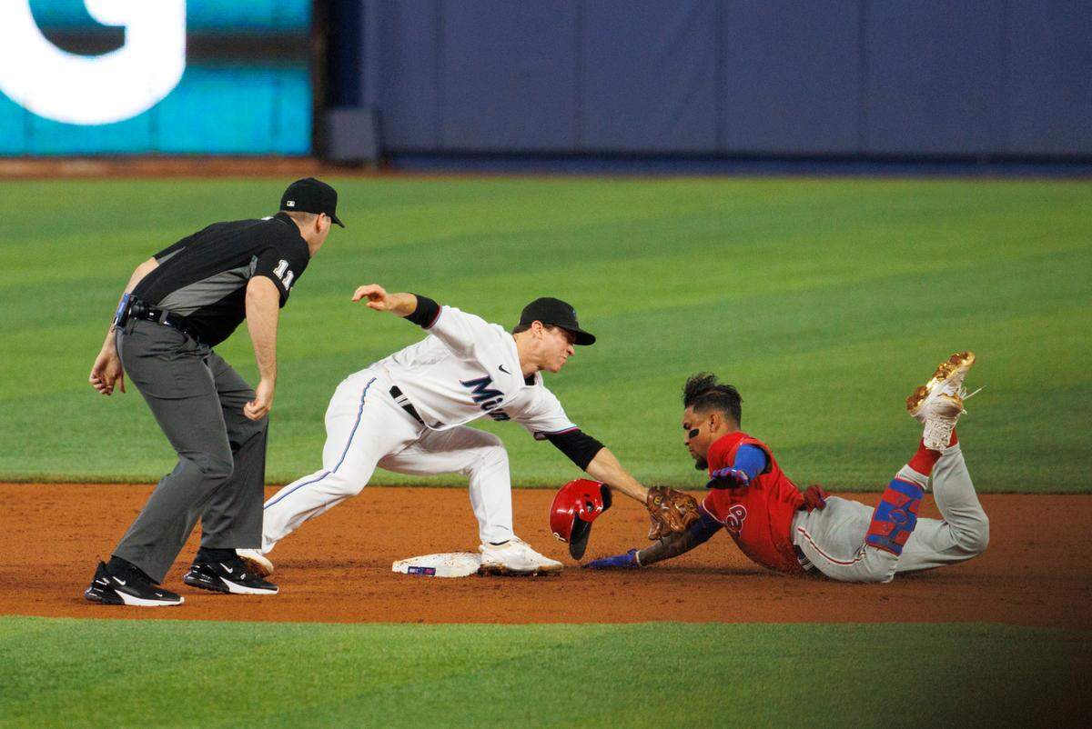 Philadelphia Phillies first baseman Johan Camargo (7) slides as Miami Marlins second baseman Joey Wendle (18) applying a tag for an out during the third inning of a baseball game at LoanDepot Park on Sunday, July 17, 2022 in Miami, Florida.