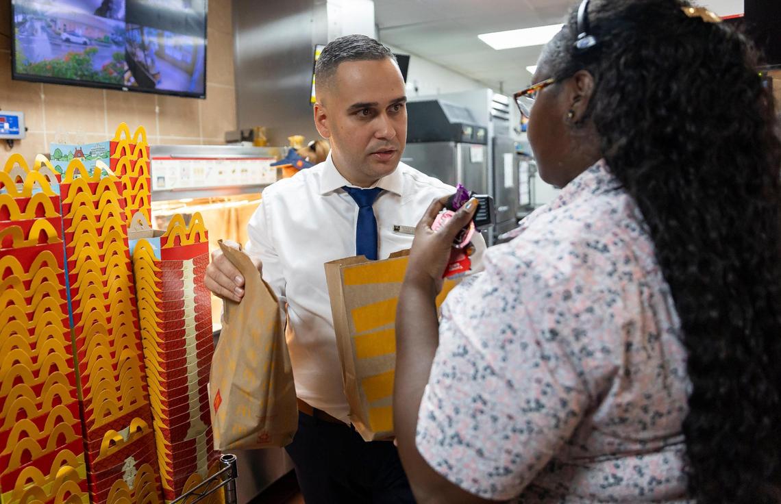 Marcial Hernandez Arias, the general manager of a McDonald’s in Miramar, speaks with swing manager, Nakita Law, as they prepare a customer’s order on Wednesday, Oct. 11, 2023. Arias has a team of 70 employees, including 28 managers.