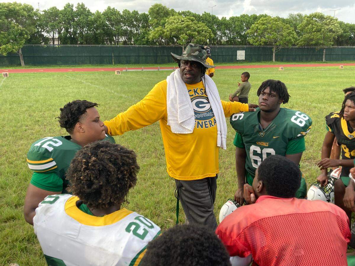 First-year Miami Jackson football coach Max Edwards talks to his players after a recent practice.