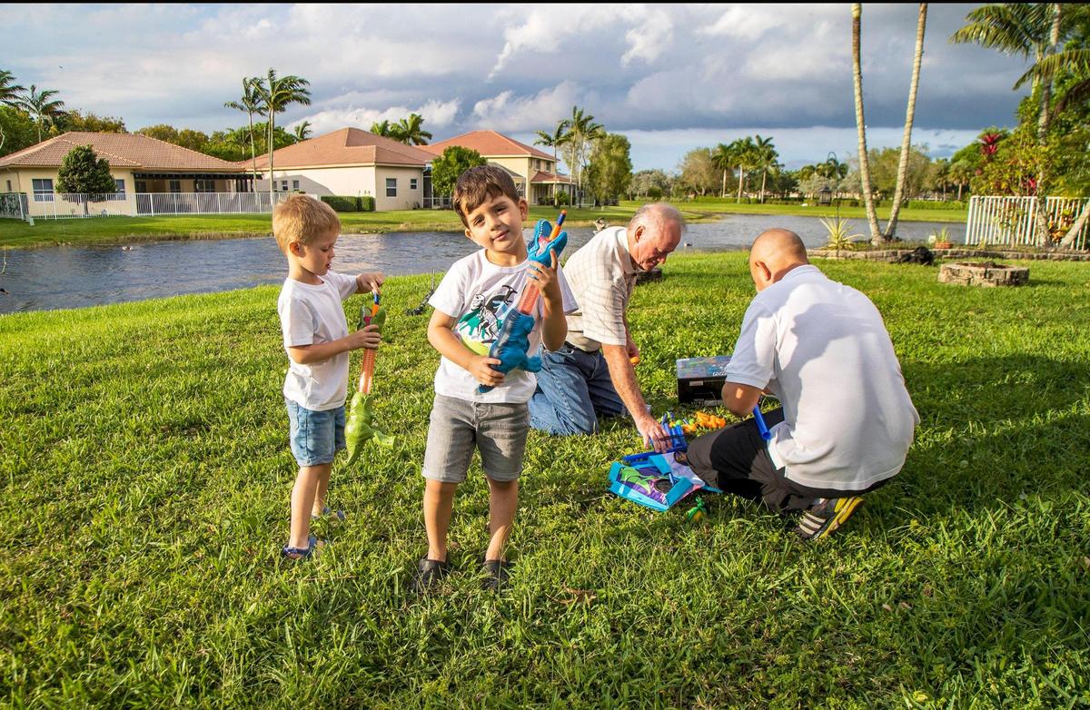 Mike Riley, left center, plays with the Ukrainian refugee family that he and his wife, Laurie, are hosting in their home in Weston, after the family left Ukraine due to the Russian invasion. Riley is with Volodymyr Nemets and his children Myroslav, 4, far left, and Volodymyr, 5, on Wednesday, May 4, 2022.
