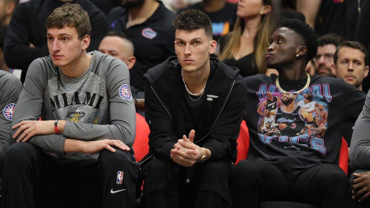 Los jugadores del Heat Nikola Jovic, Tyler Herro y Victor Oladipo (de izq. a der.) miran el juego contra los Hornets, el 10 de noviembre de 2022 en Miami.