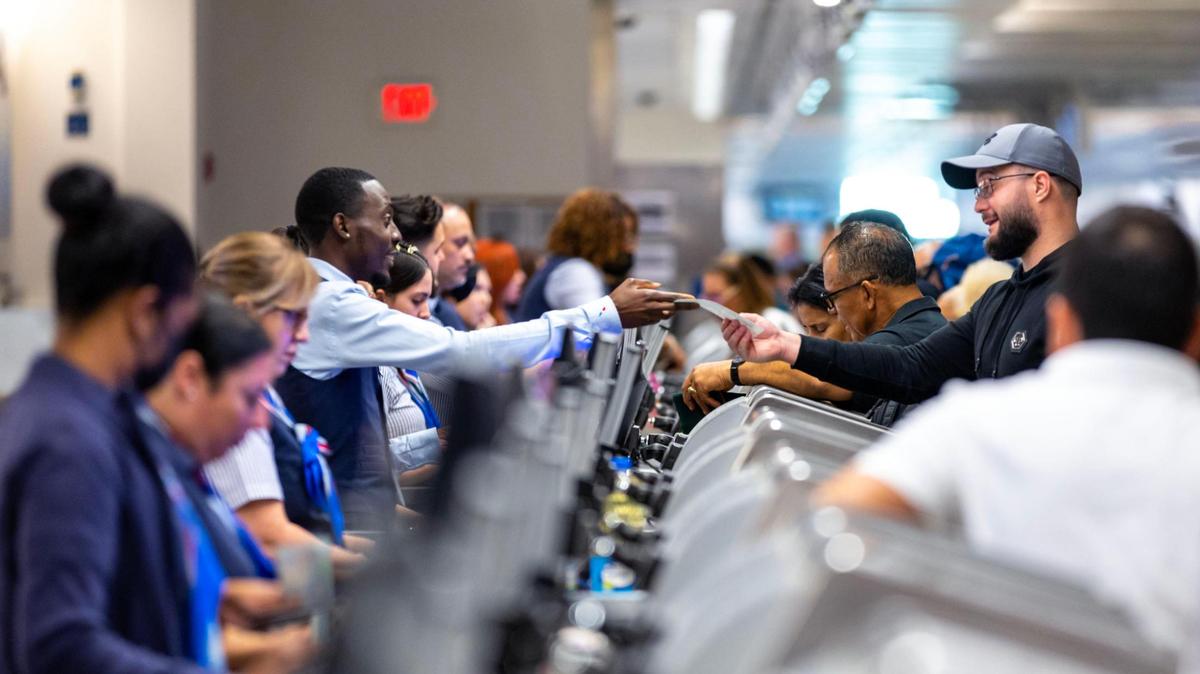 A traveler grabs his ticket from airport staff at the departures level inside Miami International Airport during the busy travel week of Thanksgiving on Nov. 23, 2022. Travelers to, and from, South Florida should expect clear skies and mild temperatures for the 2023 holiday, including Black Friday on Nov. 24, 2023.