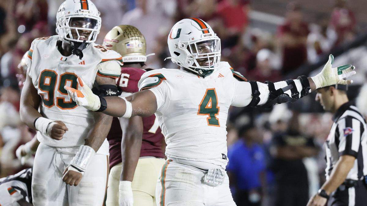 Miami Hurricanes defensive lineman Rueben Bain Jr. (4) and defensive lineman Ahmad Moten Sr. (99) react after defensive back Keionte Scott (0) recovers a fumble in the first half against the Florida State Seminoles.