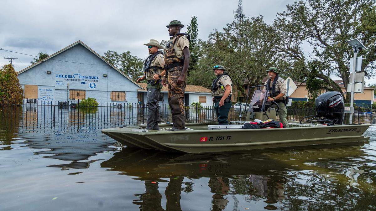 Florida Fish and Wildlife Conservation Commission officers ride a flats boat through the flooded N 12th St in North Tampa, on Thursday, October 10, 2024, a day after Hurricane Milton crossed Florida’s Gulf Coast.