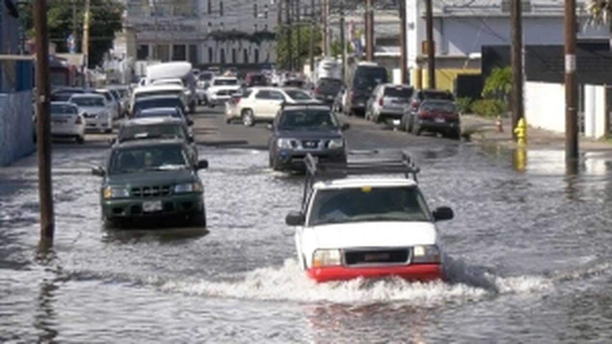 Vehículos circulan por una carretera inundada en Honolulu.
