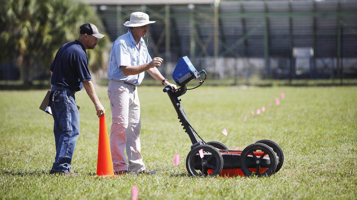 Scott Purcell, a senior geophysicist with GeoView, left, and Mike Wightman, president of GeoView use ground penetrating radar technology to scan a portion of King High campus in search for Ridgewood Cemetery in Tampa, Florida on Wednesday, October 23, 2019. (Octavio Jones/Tampa Bay Times/TNS)