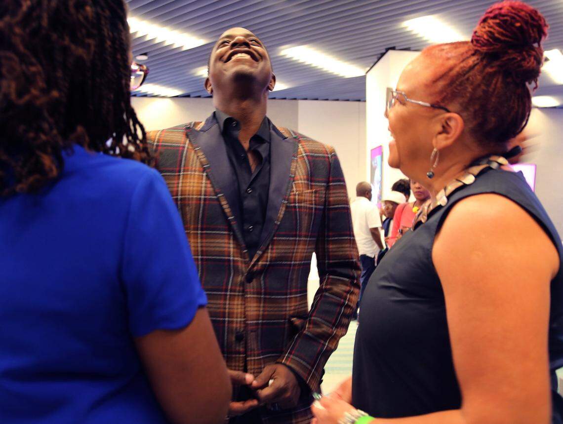 Artist Sanford Biggers, center, breaks into laughter as he shares his thoughts with gallerist Rosie Gordan-Wallace, right, during an Art of Black Miami event inside the Brightline Central Station in Overtown on Nov. 8. Art of Black Miami is organized by the Greater Miami Convention & Visitors Bureau.