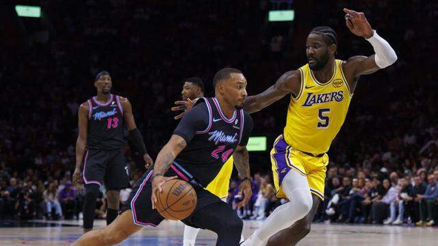 Miami Heat guard Norman Powell (24) drives around Los Angeles Lakers center Deandre Ayton (5) during the first half of a game on Thursday, March 19, 2026, at Kaseya Center in Miami.
