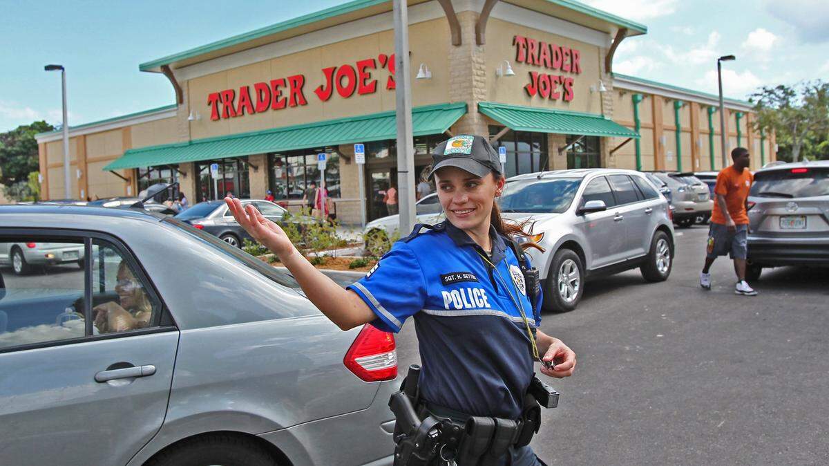 A Pinecrest officer helps shoppers jockey for parking spaces in this file photo from the 2013 opening of Trader Joe’s, the first in South Florida. The store still draws customers who fill the lot.