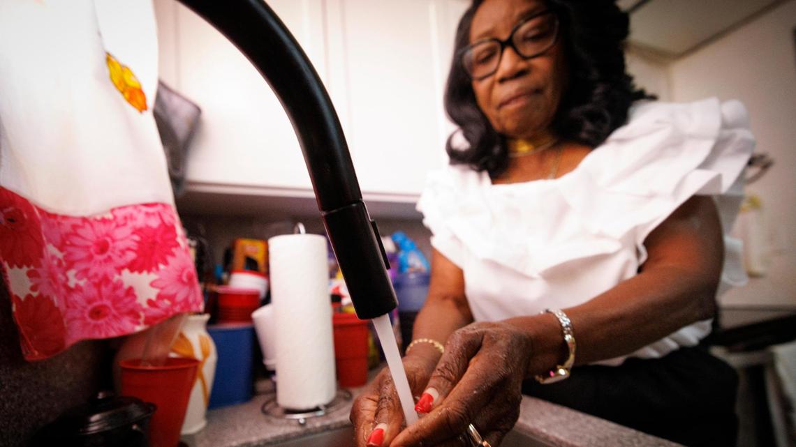 Lillie Barr washes her hands in her kitchen on Tuesday, April 15, 2025, inside her home in Miami Gardens, Florida. Barr struggles to pay her water bills as costs continue to rise.