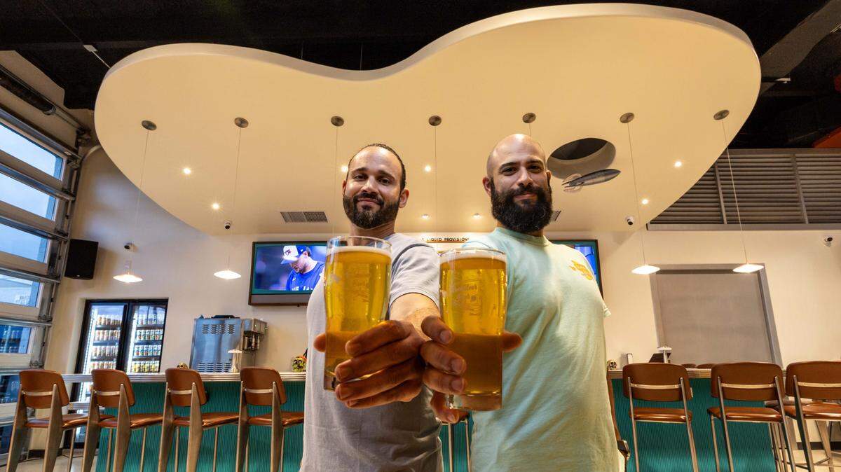 Owners and operators Rick Abreu and Rudy Delgado hold beers inside Rocketeer Beer & Liquid Provisions on Monday, October 13, 2025, in Miami, Fla.