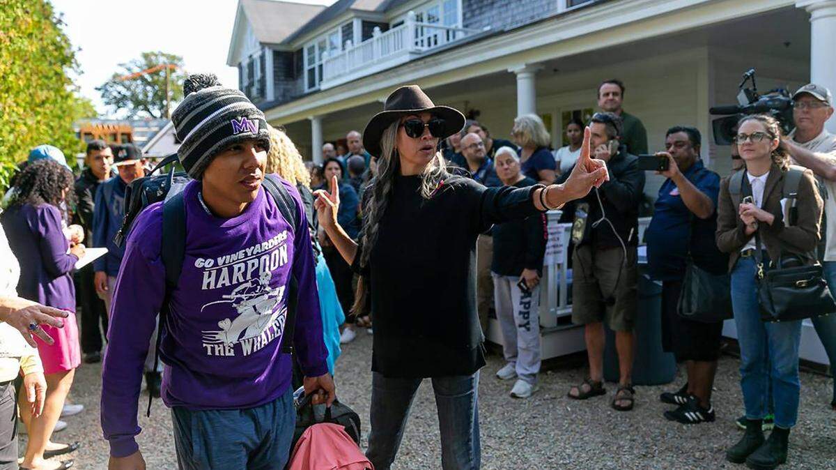 A Venezuelan migrant is led onto a bus at St. Andrews Episcopal Church on Sept. 16, 2022, in Edgartown, Massachusetts, on the island of Martha’s Vineyard. A group of migrants was flown to the island from Texas, leaving them stranded. They are here being transferred to a Cape Cod military base.