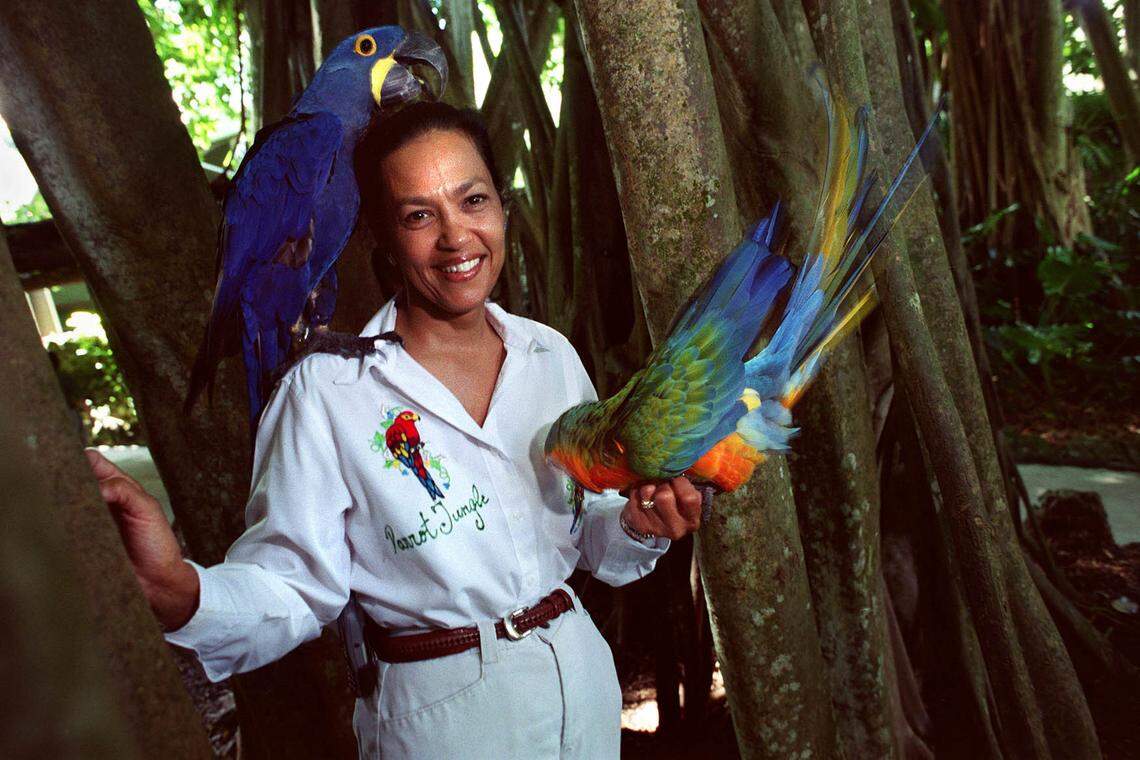 In this file photo from Sept. 9, 2002, Parrot Jungle and Gardens then-general manager Bobbie Ibarra holds birds Boomer and Ray under a Banyan tree at the park in Pinecrest.