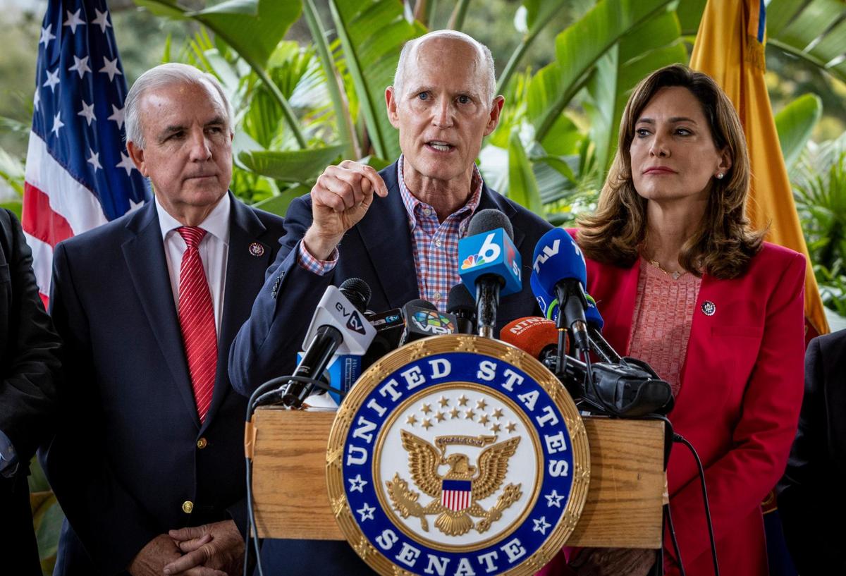 Senator Rick Scott speaks during a press conference in front of Mondongo’s Restaurant in Doral, flanked by Congressman Carlos Gimenez and Congressswoman Maria Elvira Salazar.