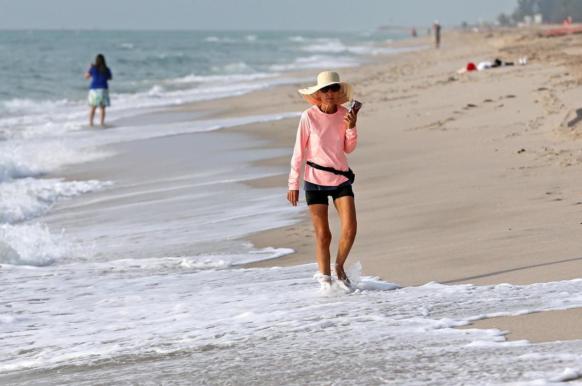 Arleen Townsend walks along Fort Lauderdale Beach as the beaches in Broward County are open on May 26, 2020 for the first time after being closed because of the coronavirus outbreak.