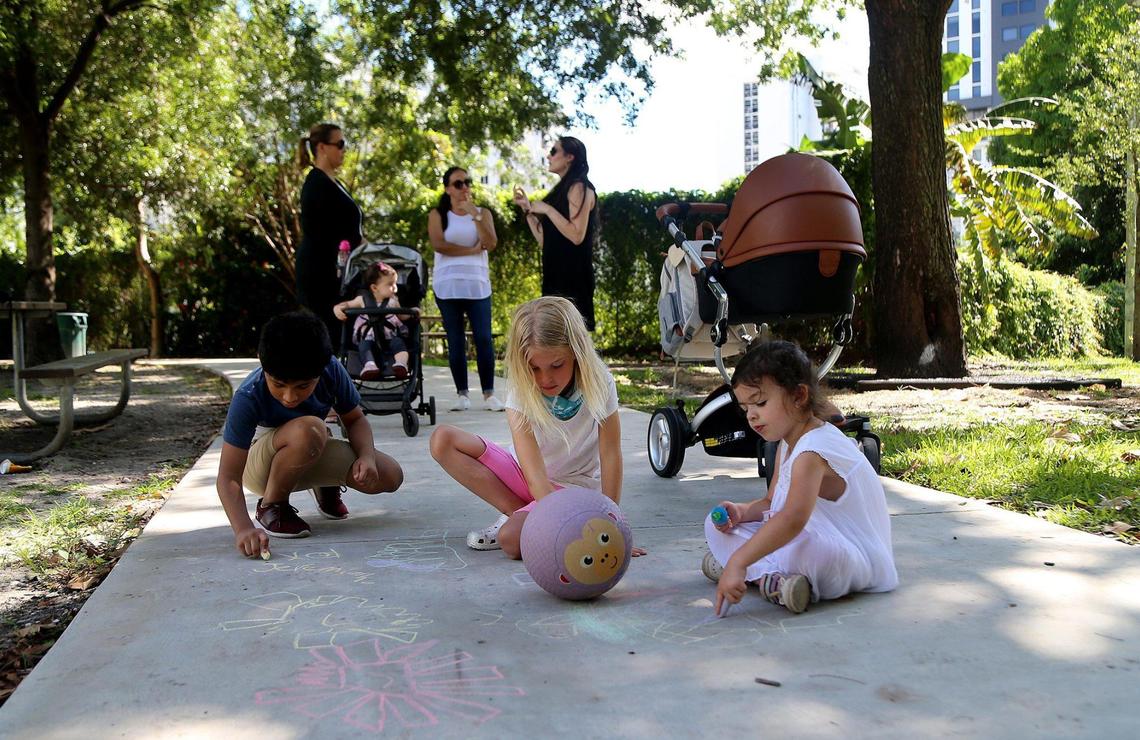 Brickell-area residents from left back, Cristina Hernandez, Nathy Amenta and Abby Ape, chat as their children — from left, Jeremiah Ape, Cristina Winker and Emi Amenta, play at Southside Park. They oppose construction of a 62-story tower adjacent to the park, which would be used for staging equipment and parking for two to three years.