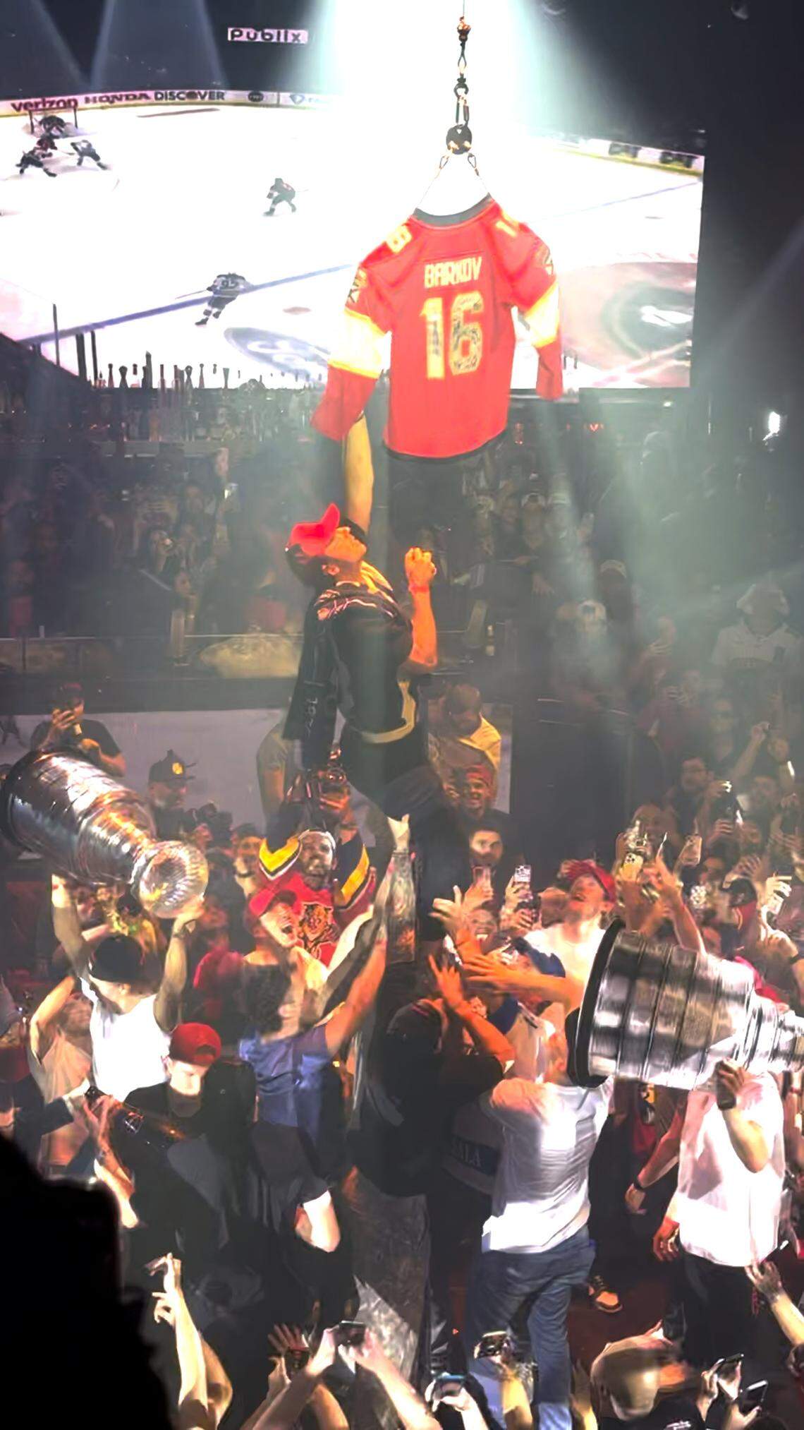 Miami, FL, June 19, 2024 - Frame grab from video shot by Amanda Rosa, Miami Herald staff. Panthers players help Sam Reinhart climb a stripper pole to grab a signed Aleksander Barkov jersey from the a trapeze bar hanging from the rafters at E11EVEN club