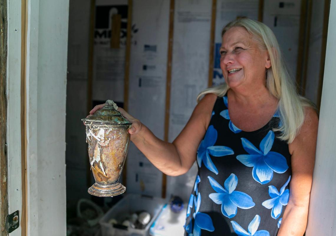 Heidi Christianson, 66, a retired landlord, holds up a candy jar that was damaged by Hurricane Ian inside her home on Tuesday, Oct. 18, 2022, in Bonita Beach, Florida.
