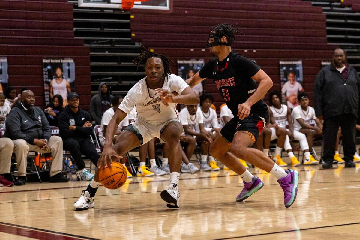Norland forward Marcus Allen (4) dribbles the ball while defended by Northeast guard Anthony Rodriguez (13) during the Regional 4-5A boys basketball semifinal in Miami Gardens, Florida on Tuesday, February 20, 2024.