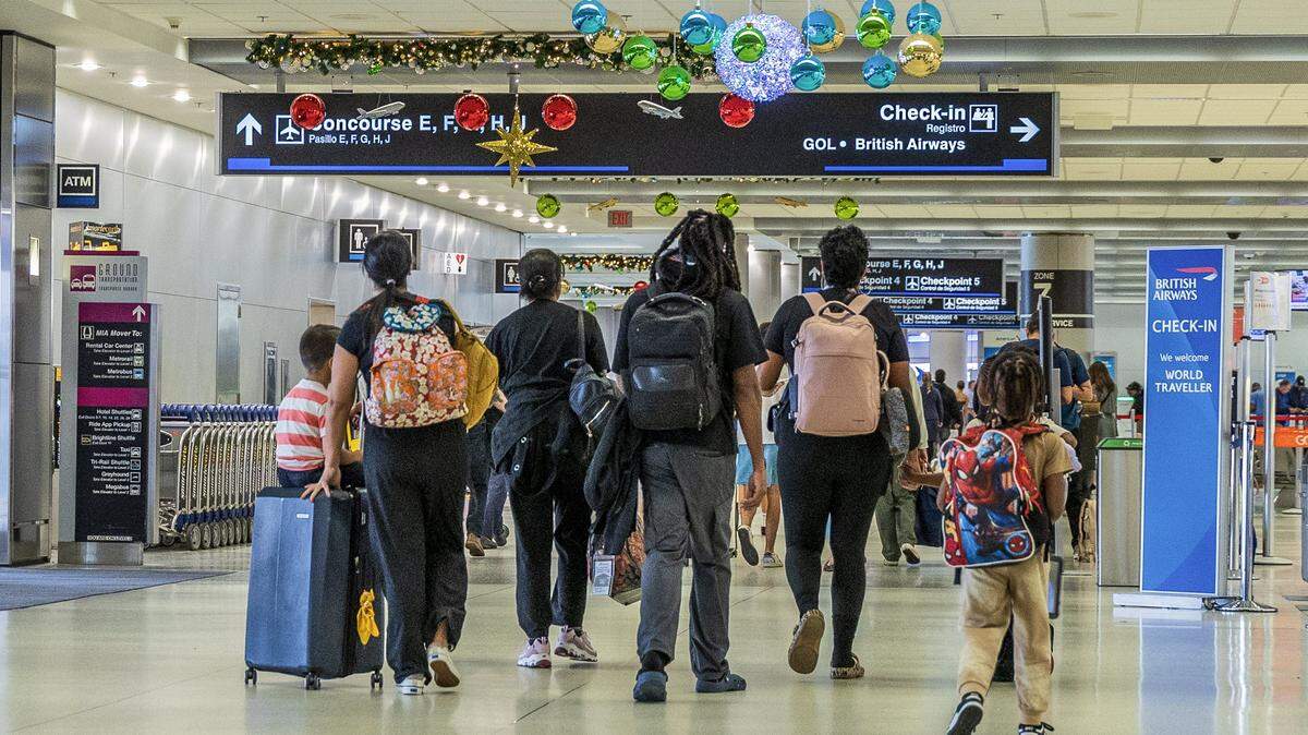 Passengers walked down the hallway in Concourse D at Miami International Airport ahead of the holidays in Miami on Nov. 21, 2025. 