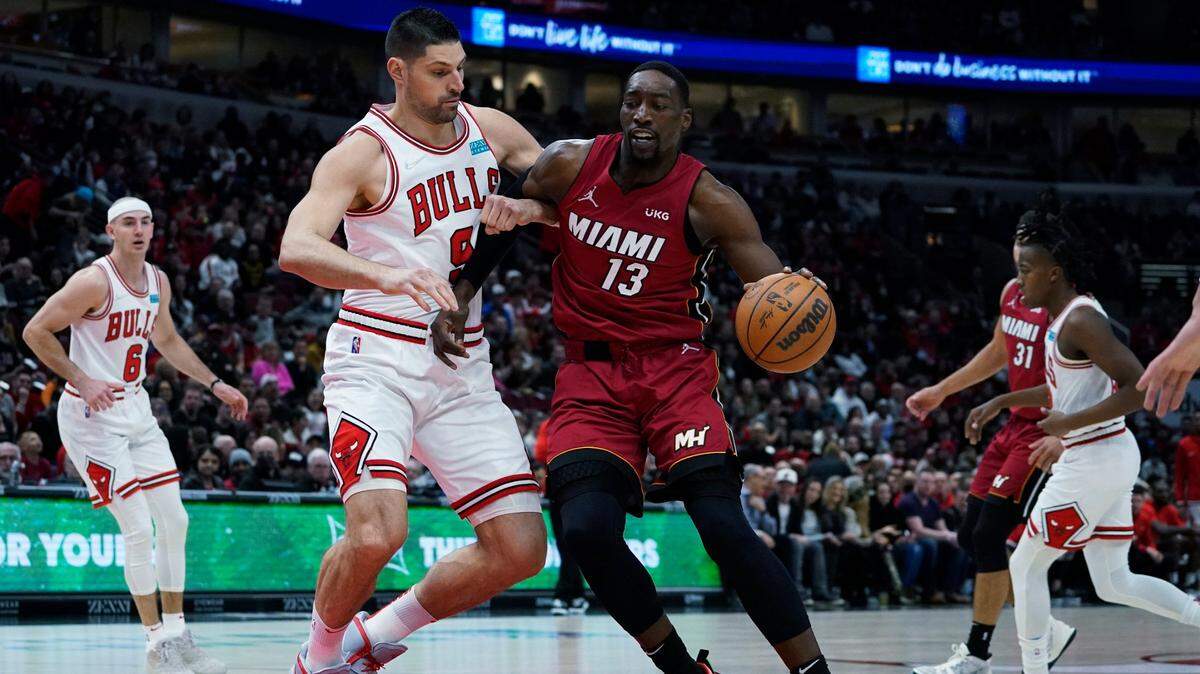 Miami Heat center Bam Adebayo, right, drives against Chicago Bulls center Nikola Vucevic during the first half of an NBA basketball game in Chicago, Saturday, April 2, 2022.