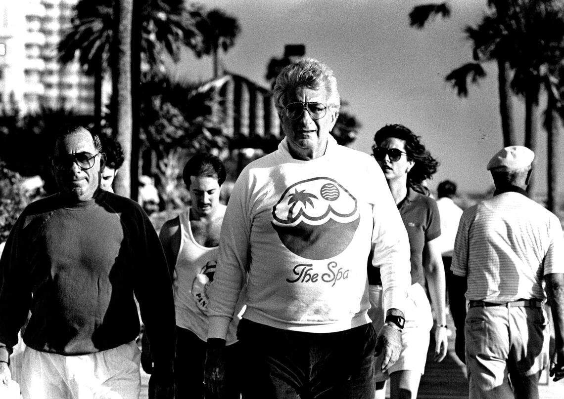 Fontainebleau Hotel owner Stephen Muss leader a group of people down the boardwalk for an exercise class.