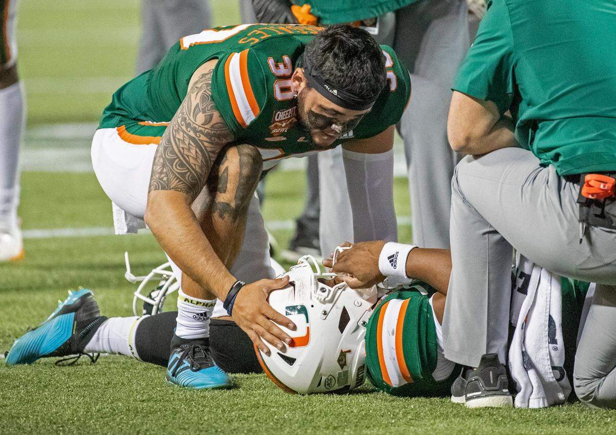 Miami Hurricanes place kicker Jose Borregales (30) consoles quarterback D’Eriq King (1) after King is injured on a tackle by Oklahoma State Cowboys safety Tre Sterling (3) in the second quarter during the 2020 Cheez-It Bowl at Camping World Stadium in Orlando on Tuesday, December 29, 2020.