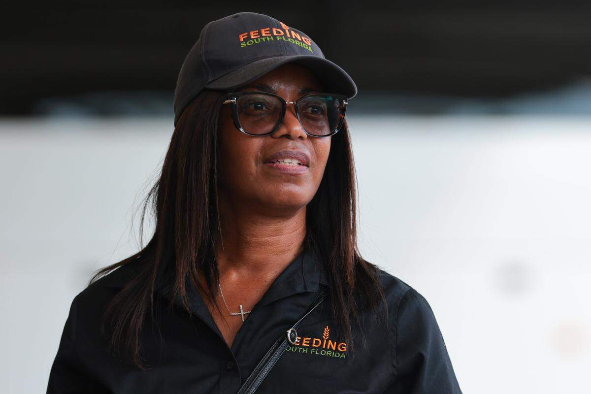 Feeding South Florida Mobile Coordinator Helen Hines watches as federal workers impacted by the government shutdown collect food items inside luggage carts at Miami International Airport in Miami, Florida, Friday, October 24, 2025.