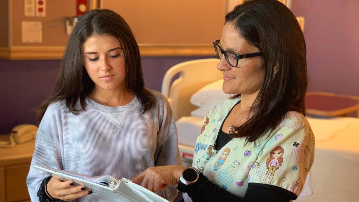 Danilza Velez, RN, a pediatric nurse with the Baptist Children’s Hospital inpatient unit, reviews diabetes resources with Haley, a patient.