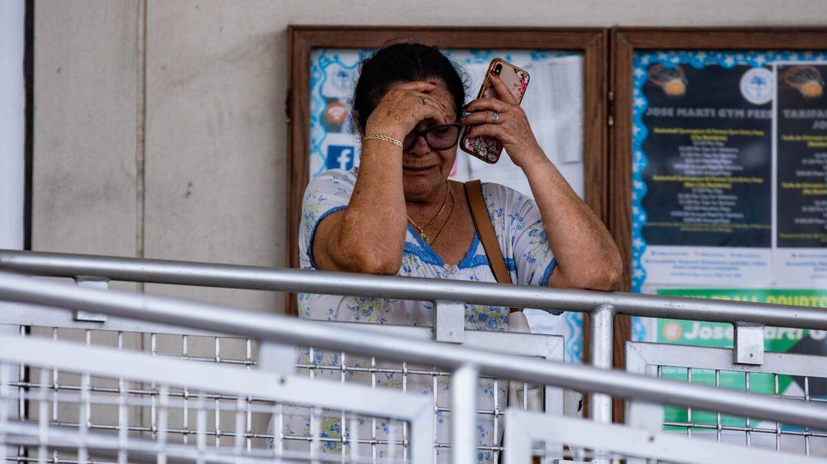 A victim of the Temple Court Apartment fire cries while speaking on the phone after arriving by trolley at the Jose Marti Gym on 434 SW and 3rd Ave. to receive aid on Monday, June 10, 2024 in Miami, Fla.