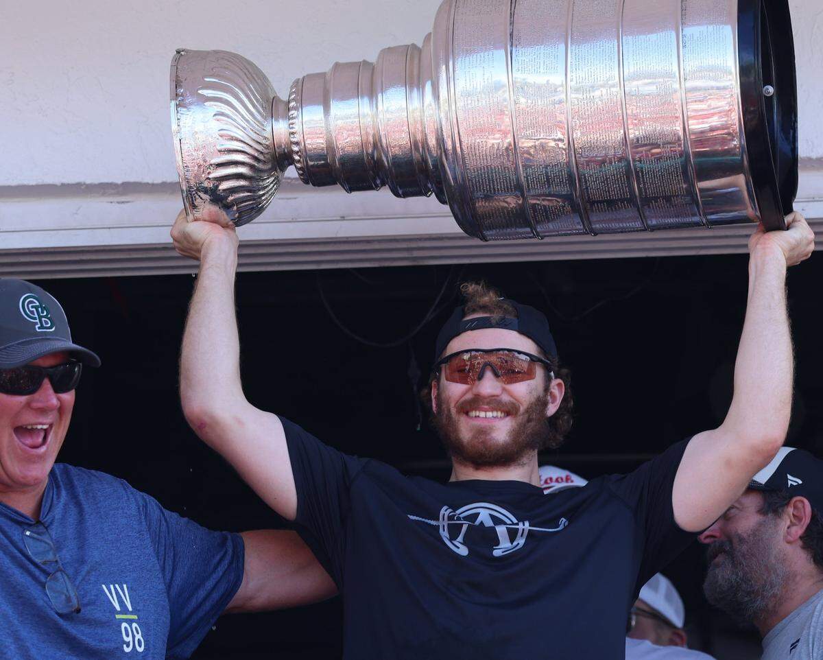 Former NHL player Keith Tkachuk, left, the father of the Panthers’ Matthew Tkachuk, right, who hoists the Stanley Cup to the cheers of fans at the Elbo Room in Fort Lauderdale, Florida on Wednesday, June 18, 2025.