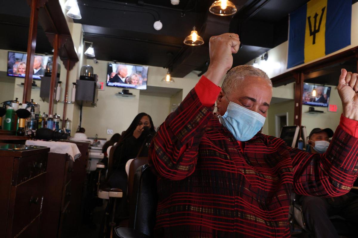 June Everett’s rejoices after the sworn-in of President Joe Biden while sitting glued to her shop’s flat screens during the telecast of the Inauguration. On Wednesday, January 20, 2021 Barbados-born barber shop owner June Everett watches along with customers and employees the Inauguration of President-elect Joe Biden and Vice President-elect Kamala Harris as the nation’s first Hispanic Supreme Court justice, Sonia Sotomayor swears in the first African-American woman of Caribbean and East Asian descent as vice president of the United States. Everett barber shop is in the heart of the U street just few block alway from HBCU, Howard University, where Vice-President Kamala Harris went to college.