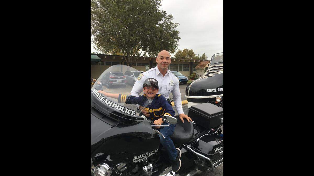 El policía de Hialeah Armando Pérez, en la foto con su hijo, fue absuelto de las acusaciones de que emitió multas de tránsito falsas.