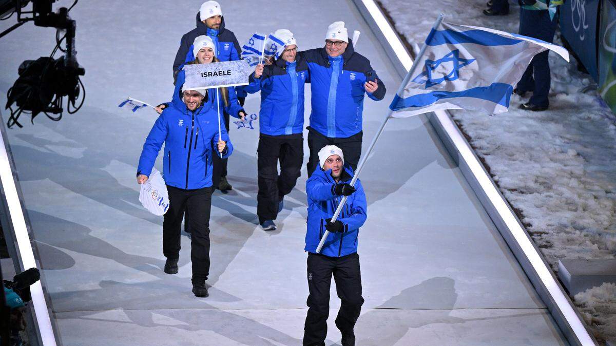 CORTINA D'AMPEZZO, ITALY - FEBRUARY 06: Flagbearer Jared Firestone of Team Israel leads the team in the parade during the opening ceremony of the Milano Cortina 2026 Winter Olympics at Piazza Dibona on February 06, 2026 in Cortina d'Ampezzo, Italy. (Photo by Mattia Ozbot/Getty Images)
