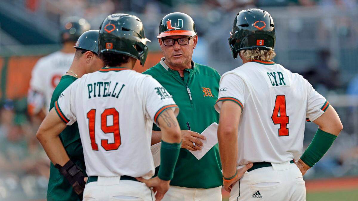 Miami Hurricanes coach Gino DiMare speaks with infielder Dominic Pitelli (19) and infielder Blake Cyr (4) during the game against the Florida International University at the University of Miami’s Mark Light Field at Alex Rodriguez Park in Coral Gables on Wednesday, May 10, 2023.