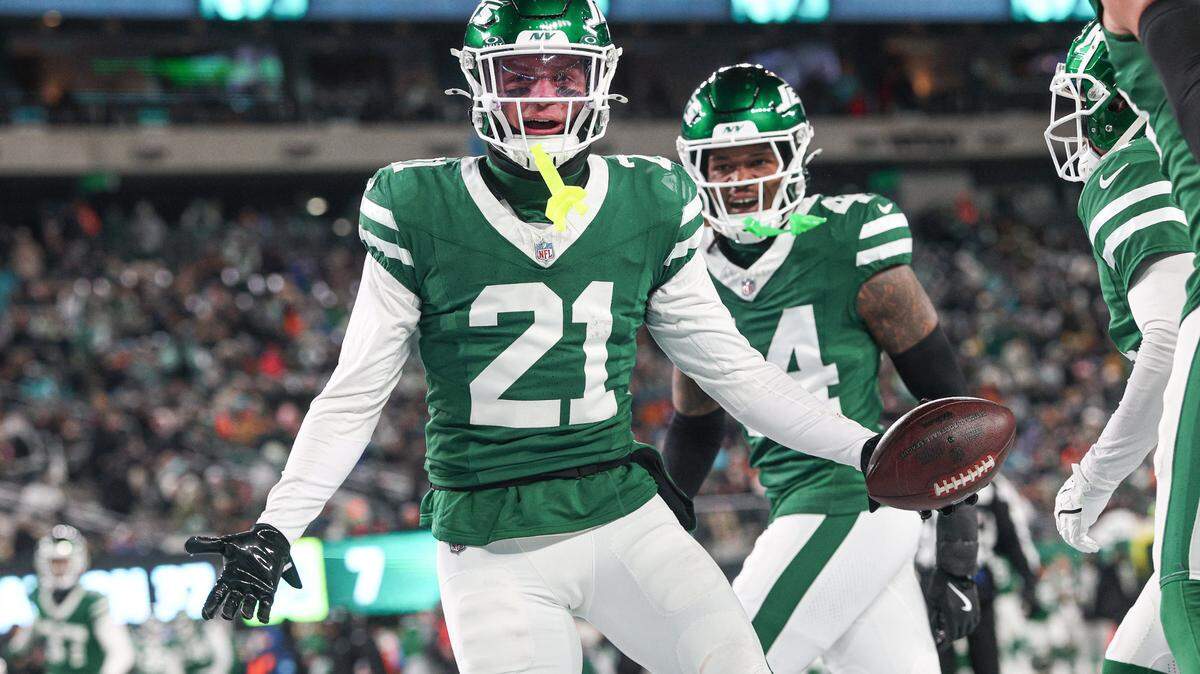 Jan 5, 2025; East Rutherford, New Jersey, USA; New York Jets safety Ashtyn Davis (21) celebrates his interception with teammates during the first half against the Miami Dolphins at MetLife Stadium. Mandatory Credit: Vincent Carchietta-Imagn Images