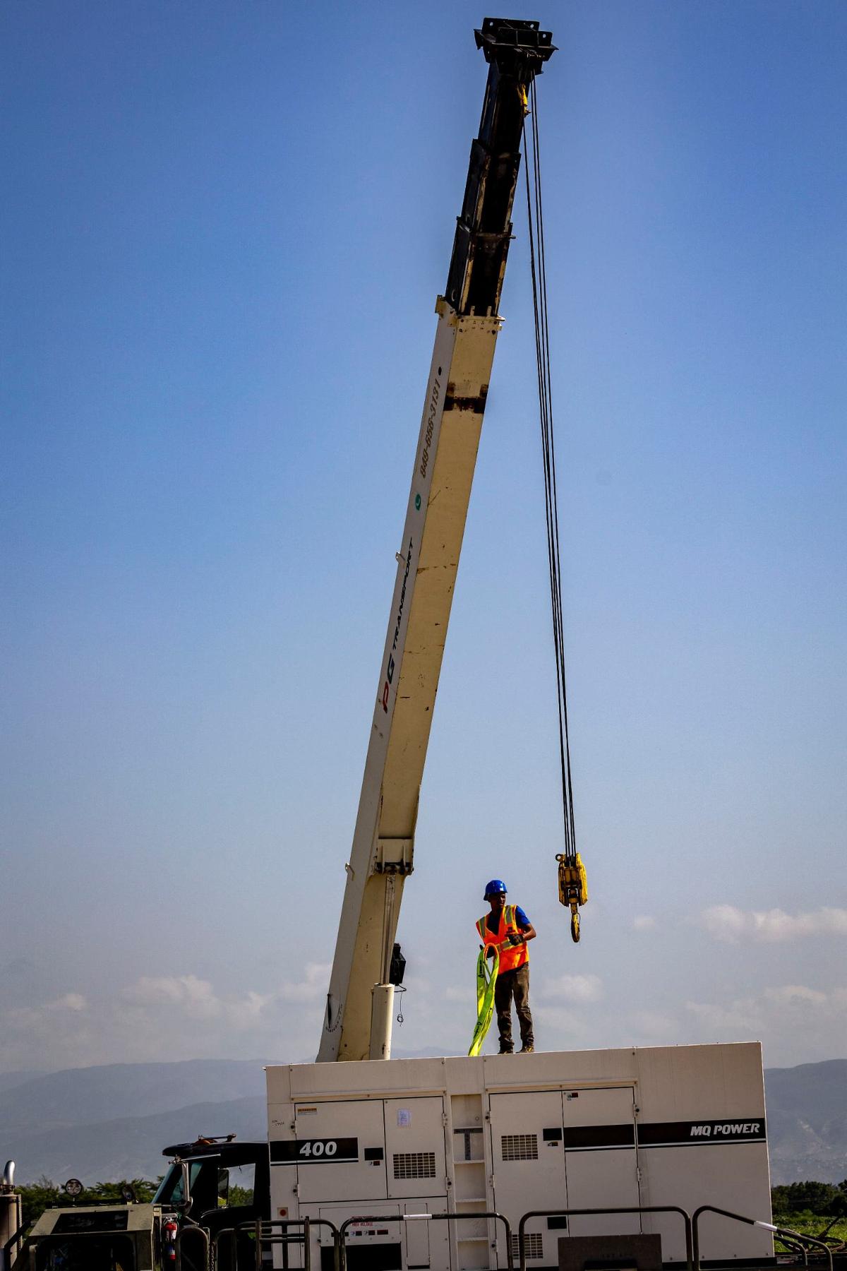 A Haitian airport worker prepares to hook up a newly delivered generator to a crane so it can be placed on a flatbed truck for transportation. On Wednesday, May 15, 2024 preparations were underway at Toussaint Louverture International Airport in Port-au-Prince, Haiti, for the imminent arrival of Kenyan police officers who are leading a Multinational Security Support mission into the country.