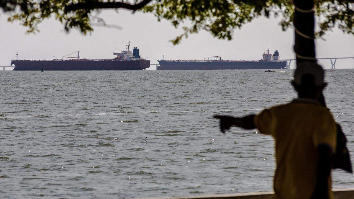 A man watches two crude oil tankers remaining anchored on Lake Maracaibo, near Maracaibo, Zulia state, Venezuela on December 17, 2025. US President Donald Trump ordered on December 16, 2025, a "total and complete blockade" of sanctioned oil tankers Venezuela has been using to bypass a six-year-old US oil embargo. 