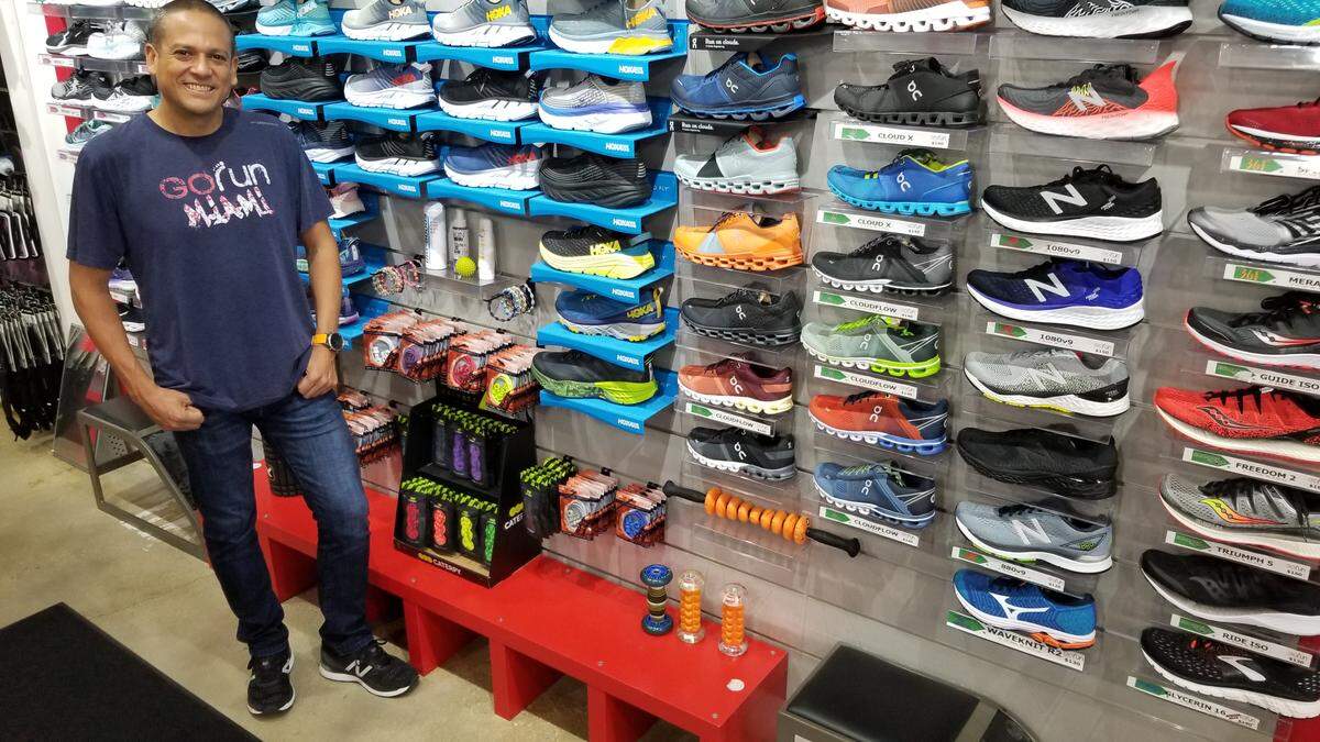 Douglas Nicaragua, 44, stands before the sneaker display of his West Kendall store Go Run on Tuesday, March 17. Nicaragua said he is temporarily closing the store due to a dramatic drop in business.