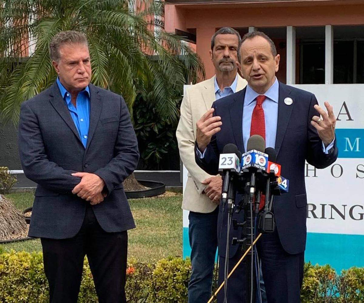 In this March photo posted on the Facebook page of Jack Michel, CEO of Larkin Community Hospital, Michel and Hialeah Mayor Carlos Hernandez (left) announce the opening of a drive-thru testing site for COVID-19 that charges $150.