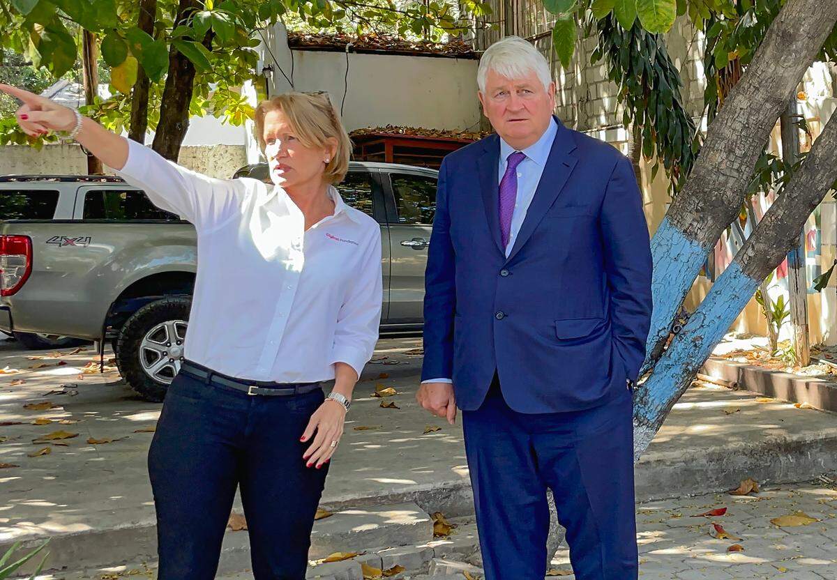 As Digicel Foundation CEO Sophia Stransky points out where a new building could be erected in the yard of Institution Mixte Notre Dame de l’Assomption in Port-au-Prince, Haiti, on Thursday, Feb. 16, 2023, Digicel Group Chairman Denis O’Brien takes in the landscape, then asks, “Will there be room for a football field?”