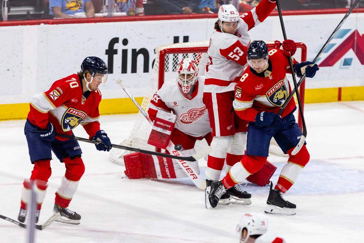 Florida Panthers center Jesper Boqvist (70) attempts to deflect a shot around Detroit Red Wings goaltender Cam Talbot (39) as Florida Panthers center Nico Sturm (8) boxes out defenseman Moritz Seider (53) during the first period of an NHL game at Amerant Bank Arena on Thursday, April 10, 2025, in Sunrise, Fla.