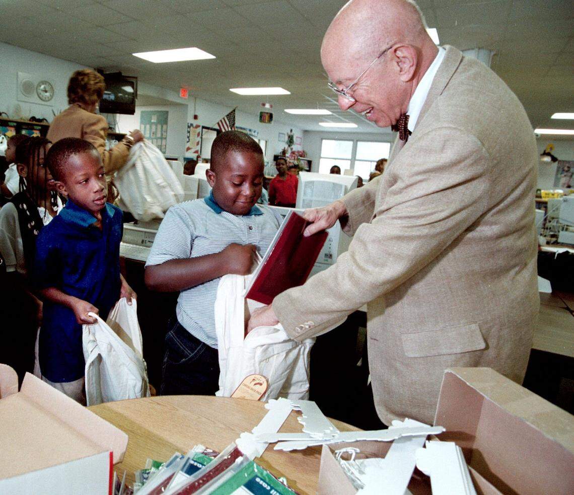 In this Sept. 6, 2001 file photo, Dr. Wil Blechman, a Kiwanis president, gives then-Fulford Elementary second-grade student Wilson Milen school supplies donated by the Kiwanis as classmate Lames Voicr waits his turn in the school library.