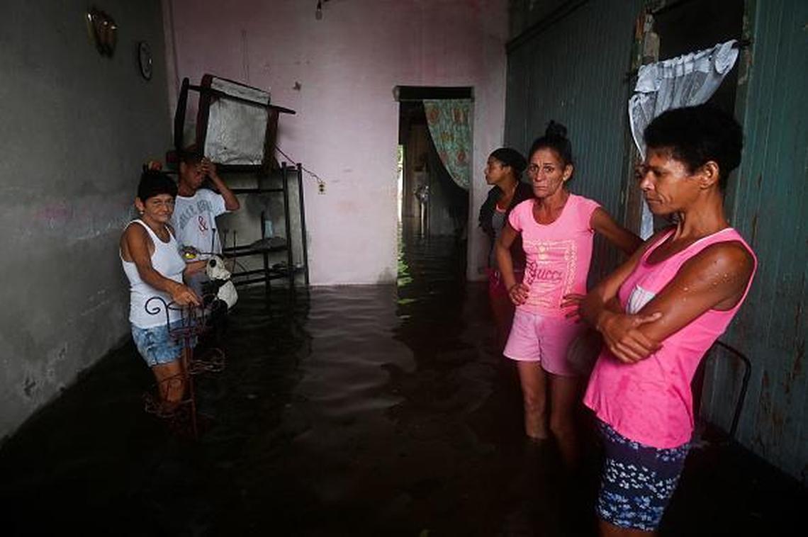A family waits inside their flooded home in the town of Batabano, in western Cuba, on Sept. 27, 2022, during the passage of hurricane Ian.