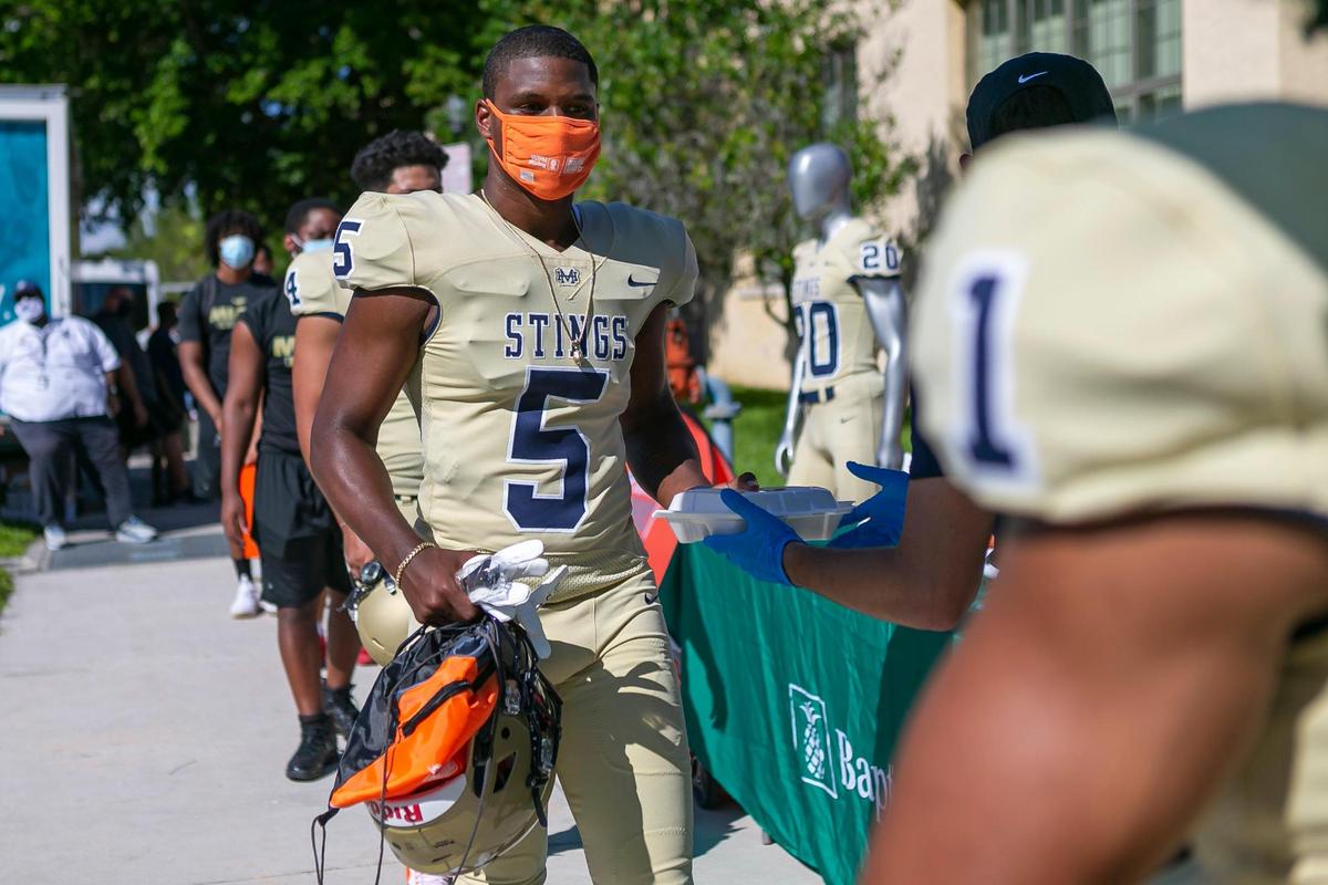 Tramaine Gulfin, 16, a junior at Miami Senior High and a member of the schoolÕs football team, receives free food during a Miami Dolphins Youth Program event at the school in Little Havana on Wednesday, October 14, 2020. The Miami Dolphins visited the student athletes of Miami Senior High School to distribute 300 meals and 100 fit kits which include cones, stretch bands, a jump rope and mask. The schoolÕs football team also received equipment, cleats and new football uniforms provided by Nike.