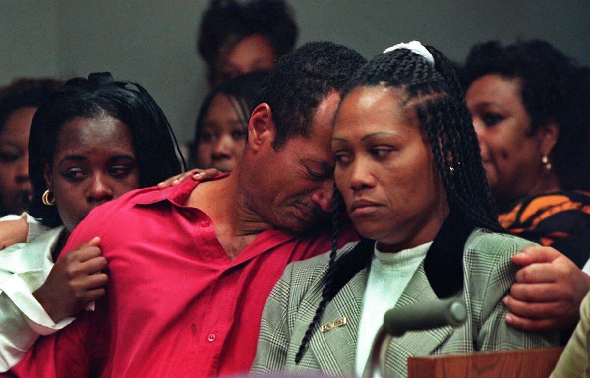 Dewayne Lee, father of murder victim Timwanika Lumpkins, leans on Charlie Postell, mother of murdered UM football player Marlins Barnes, as they react to the guilty verdict of defendant Labrant Dennis in 1998.