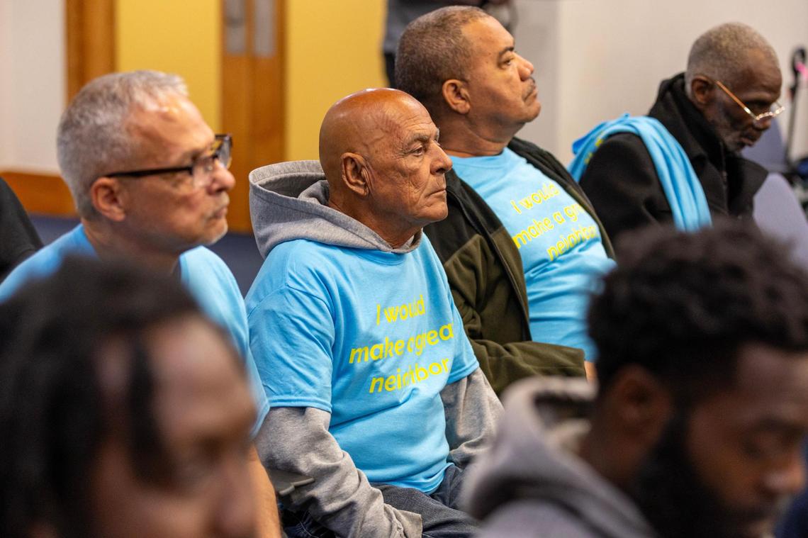 Supporters of a plan by the Miami-Dade County Homeless Trust to convert a motel in Cutler Bay into affordable apartments for the formerly homeless listen to a town council forum on the proposal while wearing t-shirts that read: “I would make a great neighbor.”