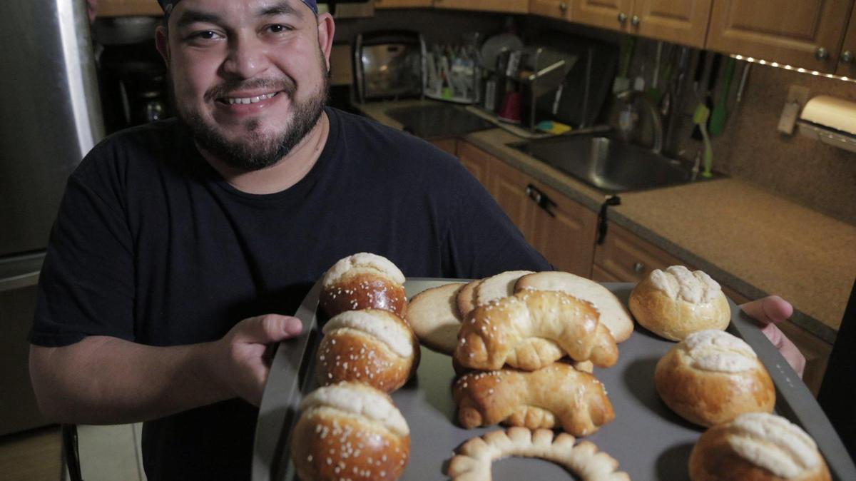 Eddy Llamas holds a tray of different Guatemalan breads that he bakes in his home kitchen in Miami, Florida, June 2, 2020. After being temporarily laid off from his job at a restaurant because of the coronavirus pandemic, he decided to bake these Guatemalan breads to sell to other Guatemalans.