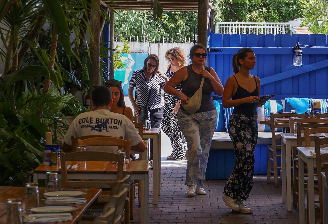 Lunchtime dinners are escorted to their courtyard table at Mandolin Aegean Bistro.