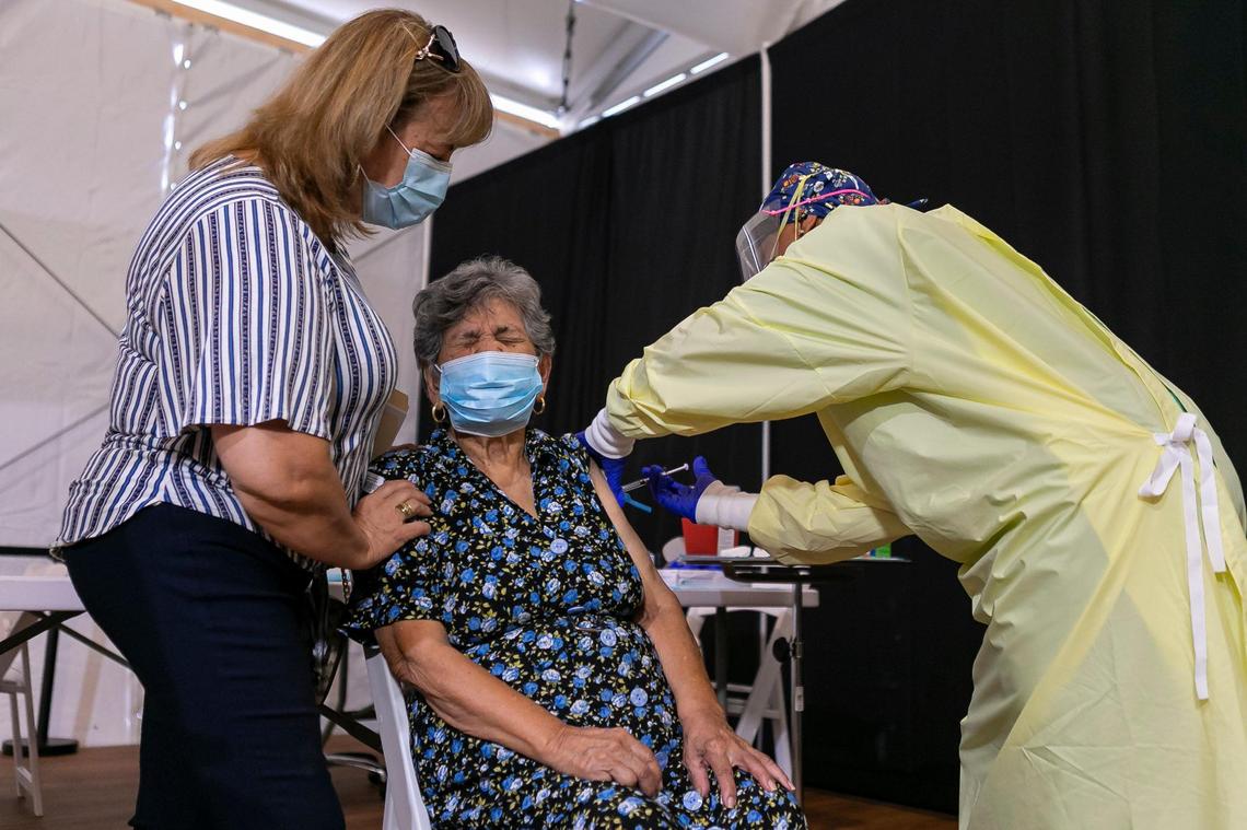 Luz Rincon, 66, left, holds her mother, Julia Rincon, 96, as Tania Jones, a licensed practical nurse, administers the Moderna vaccine at a new walk-up COVID-19 vaccination site in Miami’s Overtown neighborhood on Tuesday, March 2, 2021.